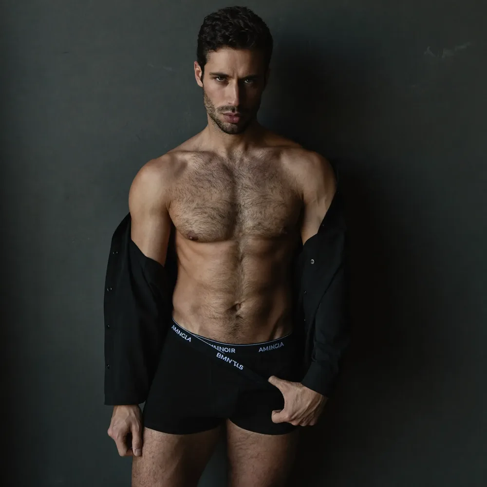 Male boudoir pose against a concrete wall